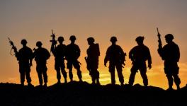 American soldiers in a remote post, silhouetted against the dimming Afghan sky.