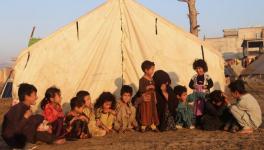 Internally displaced children sit outside a tent at a refugee camp, Khost province, Eastern Afghanistan, November 17, 2020