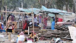 People collect their belongings after a demolition drive carried out by the railways in Shakur Basti of Delhi on Sunday. 