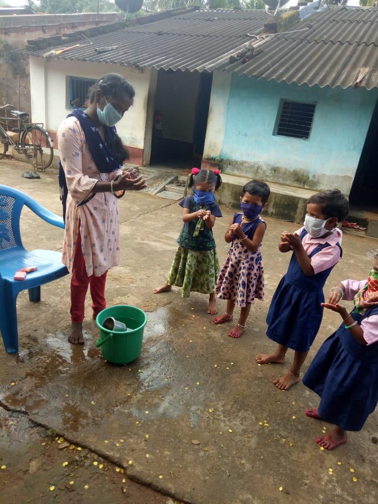 Children are standing in a queue to wash their hands