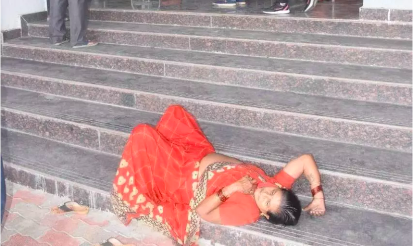 A woman lies unconscious at the stairs of a government hospital in Vidisha.