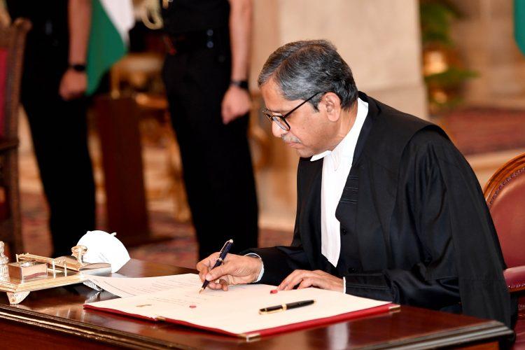 CJI NV Ramana signs the register after being sworn in as CJI in Rashtrapati Bhavan.