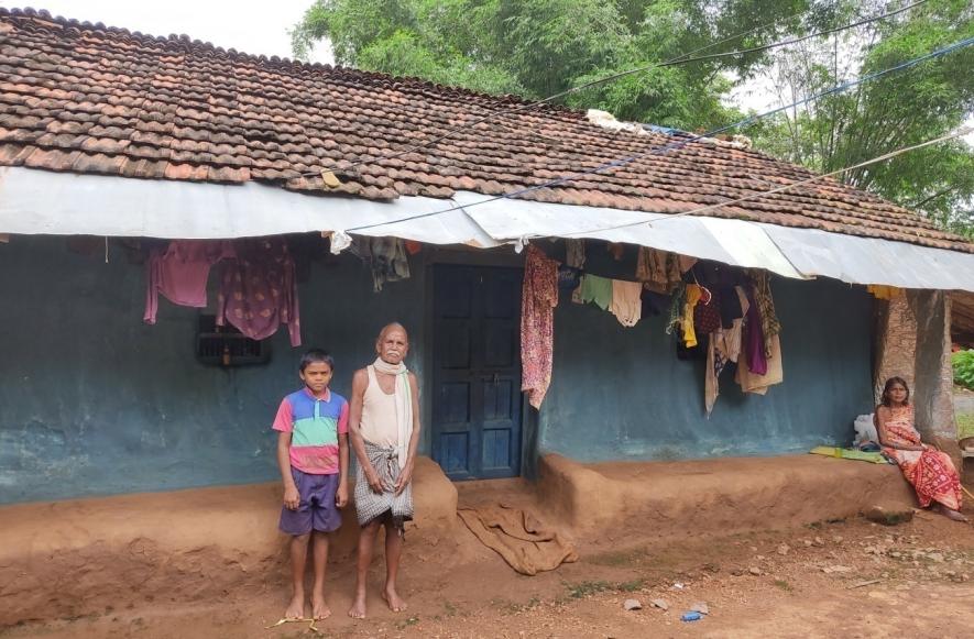 Sagar with grandparents outside his mud house