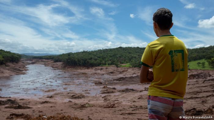 A boy looks at the mud that reached the city of Brumadinho, in Brazil, after a dam at an iron-ore mine collapsed in January 2019. Hundreds were killed in the disaster.