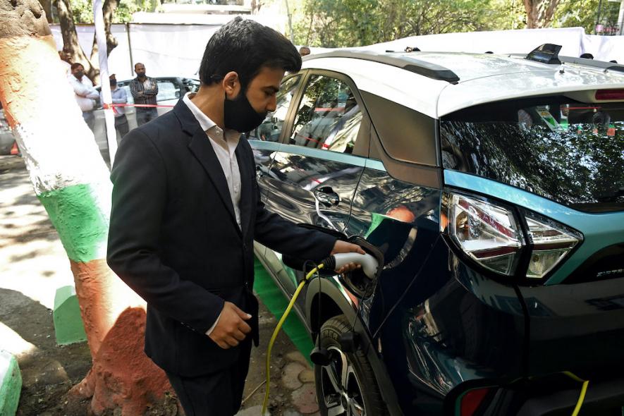 A resident member tests a new electric vehicle charging station, at Vasant Kunj, in New Delhi