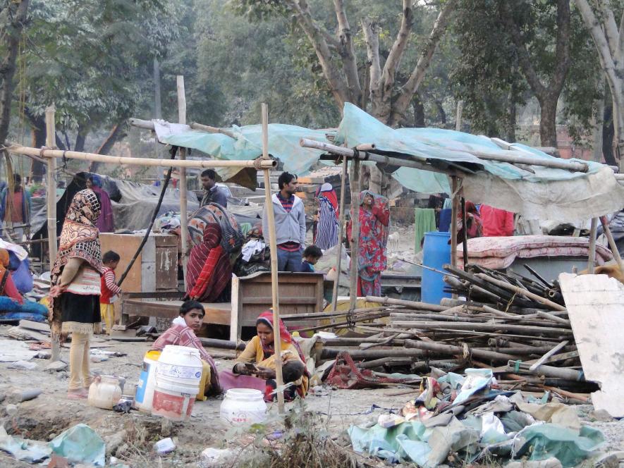 People collect their belongings after a demolition drive carried out by the railways in Shakur Basti of Delhi on Sunday. 