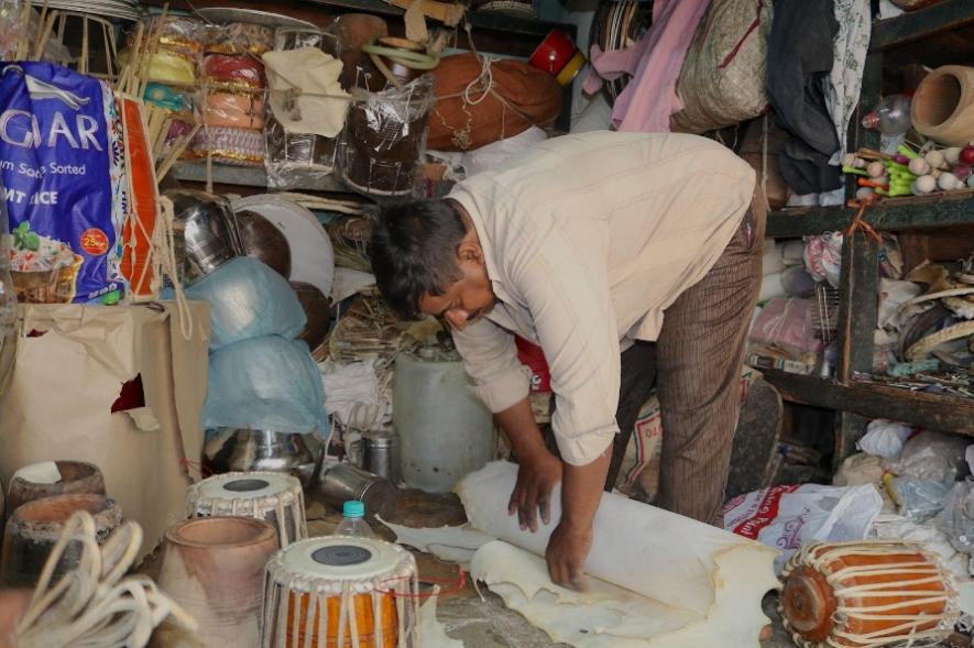 Mohammad Jaffer rolls the raw leather mats.