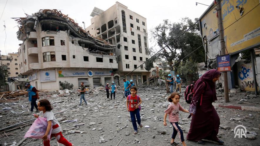 Residents move away for safer spots amid destroyed buildings and debris around the Palestinian Telecommunications Company, which was targeted, after Israeli airstrikes in Gaza Strip on October 10, 2023. Photo: Anadolu Agency