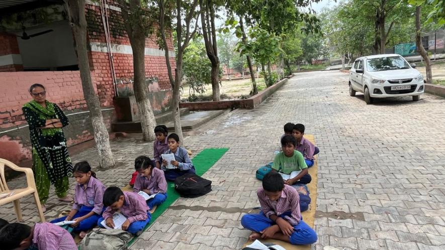 Classrooms being held under a tree at the government school in Kasandi.