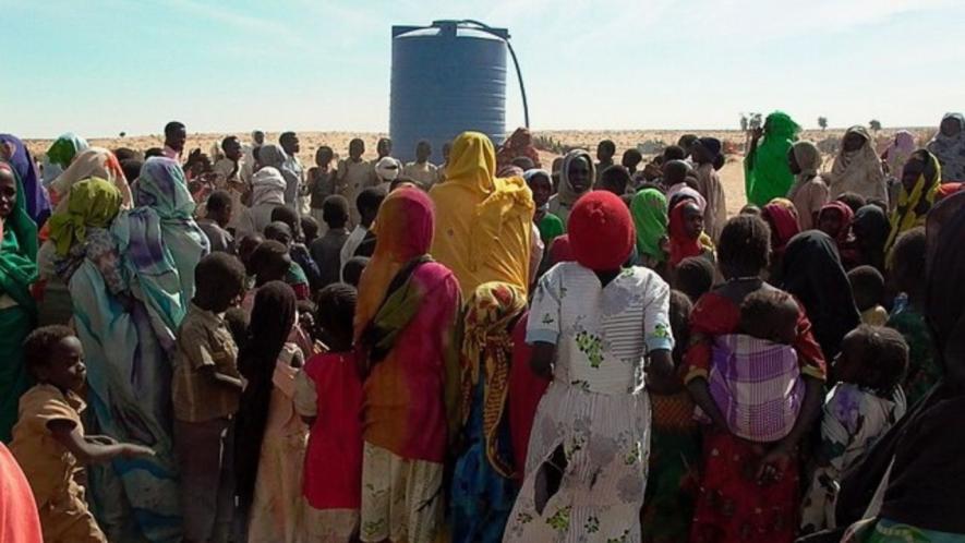 Internally displaced persons with water tank in West Darfur. Photo: Wikimedia commons